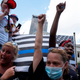 Black Lives Matter protestors raise their fists in front of a “Blue Lives Matter” flag during an anti-mask right-wing protest “Stand For America Against Terrorists and Tyrants” at State Capitol on July 18, 2020 in Columbus, Ohio.
